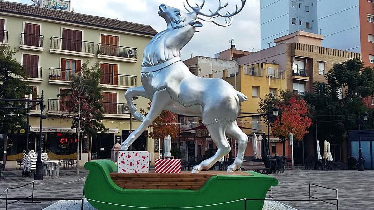 A la izquierda, el Rudolph elaborado por Palacio i Serra e instalado en la plaza del Prado de Gandia y, a la derecha, el cartel de felicitación de Sanchis en la plaza Major. | LEVANTE-EMV