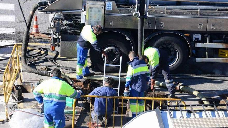 Trabajadores de la empresa en el bombeo situado cerca del Concello. // Gonzalo Núñez