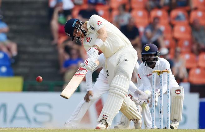 El capitán de Inglaterra, Joe Root (L) juega un tiro mientras el jugador de Sri Lanka, Niroshan Dickwella (R), observa durante el segundo partido amistoso entre Sri Lanka e Inglaterra en el Estadio Internacional de Críquet de Pallekele en Kandy.