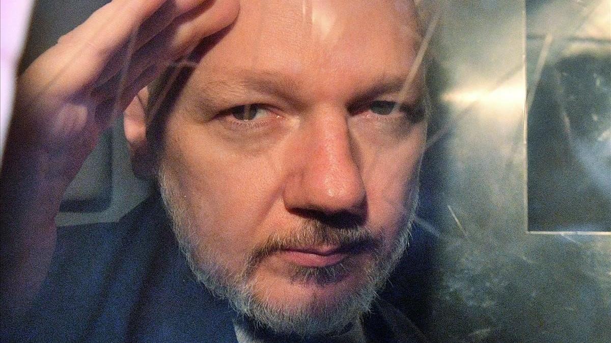 Assange, observa desde la ventana de una furgoneta policial, en Londres, el año pasado.