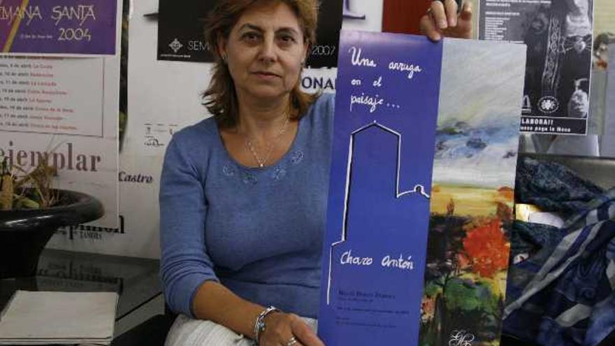Charo Antón muestra el cartel de su nueva exposición en el Meliá