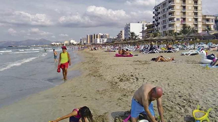 Una socorrista camina por la orilla de una poco concurrida playa de can Picafort.