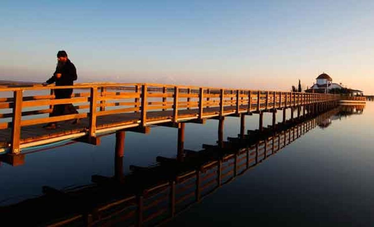Un monjo grec ortodox camina pel pont de l’església de Sant Nicolau al nord de Grècia.