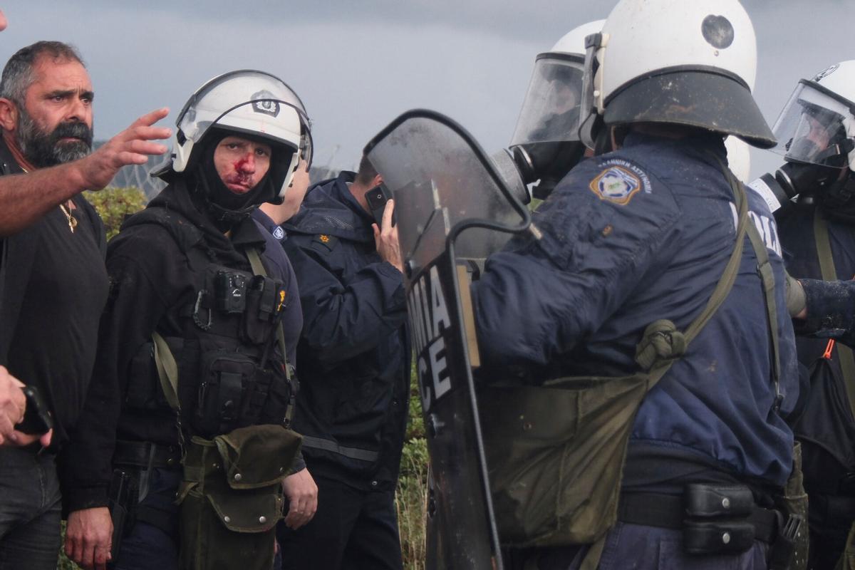 A injured police officer stands next to his colleagues during clashes with officers blocking their march to Chanias airport on Crete, Greece, Monday, Dec. 8, 2025, amid protests over delayed EU farm subsidies. (AP Photo/Giannis Angelakis)