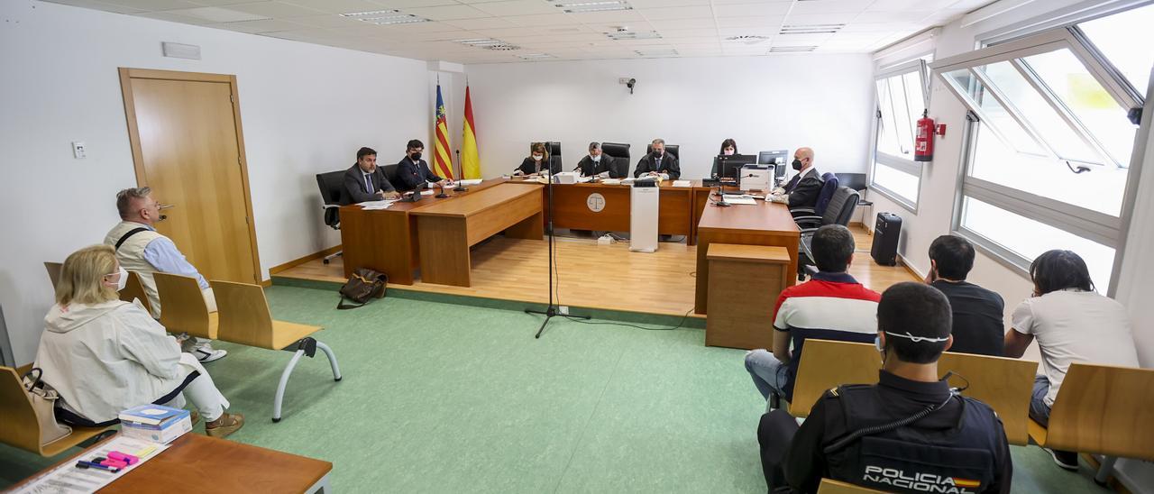 Los cuatro acusados sentados de espaldas en la primera fila antes del inicio del juicio.