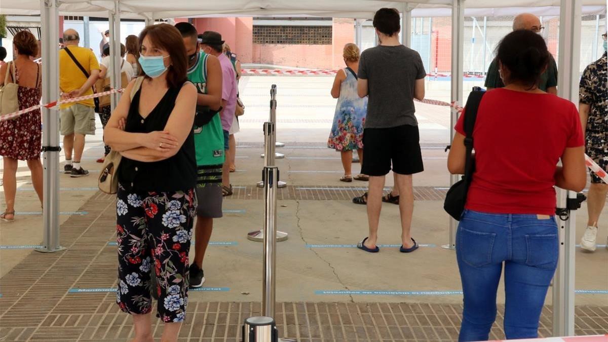 Vecinos del barrio de Sant Ildefons de Cornellà de Llobregat haciendo cola para hacerse una prueba PCR.