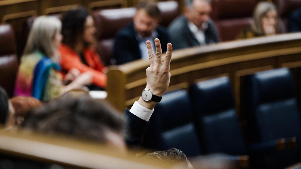 Una persona indica el número de votación durante una sesión plenaria, en el Congreso de los Diputados.