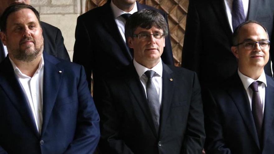 Puigdemont, envoltat pel vicepresident Junqueras i pel nou conseller de Presidència, Jordi Turull.