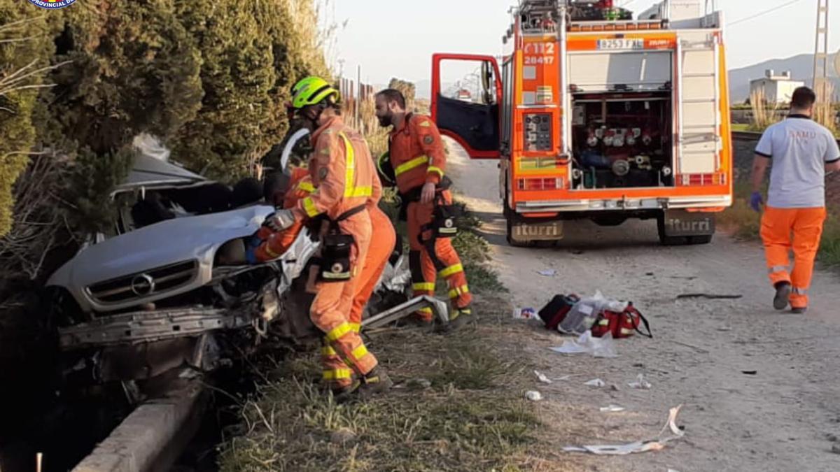 Los bomberos ante el coche arrollado por el tren