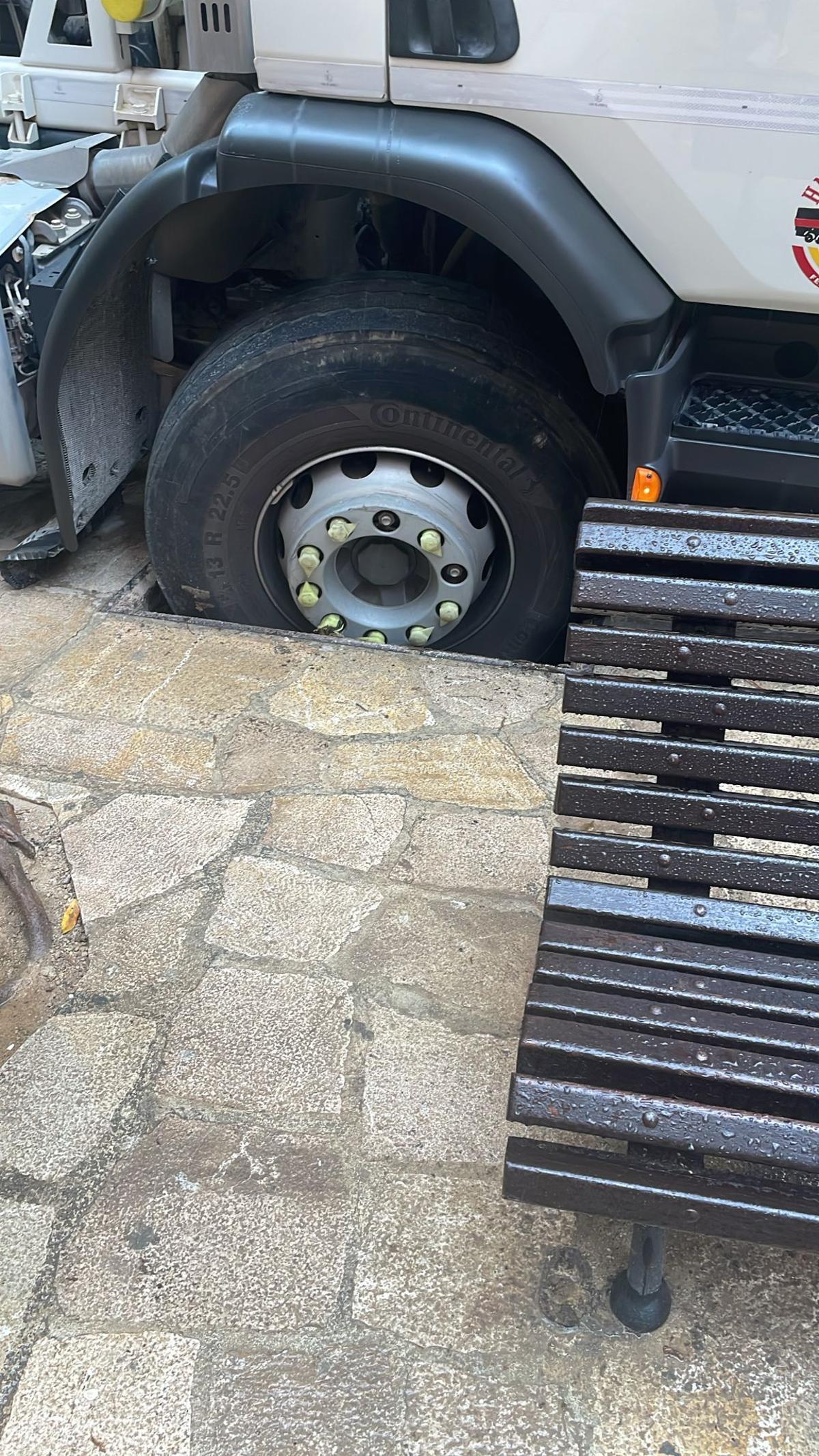 La rueda del camión ha quedado encajada en el agujero de la alcantarila.
