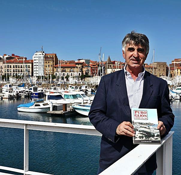 José Luis Carmona con un ejemplar del libro, en el puerto deportivo. | Juan Plaza