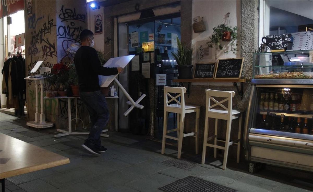 Trabajo dice que no se esperan enormes cambios en los ERTE en la nueva negociación. Así lo explica el secretario de Estado de Trabajo y Economía Social, Joaquín Pérez Rey. En la foto, un camarero recoge las mesas de la terraza de un bar en Palma de Mallorca, a finales de diciembre del 2020.