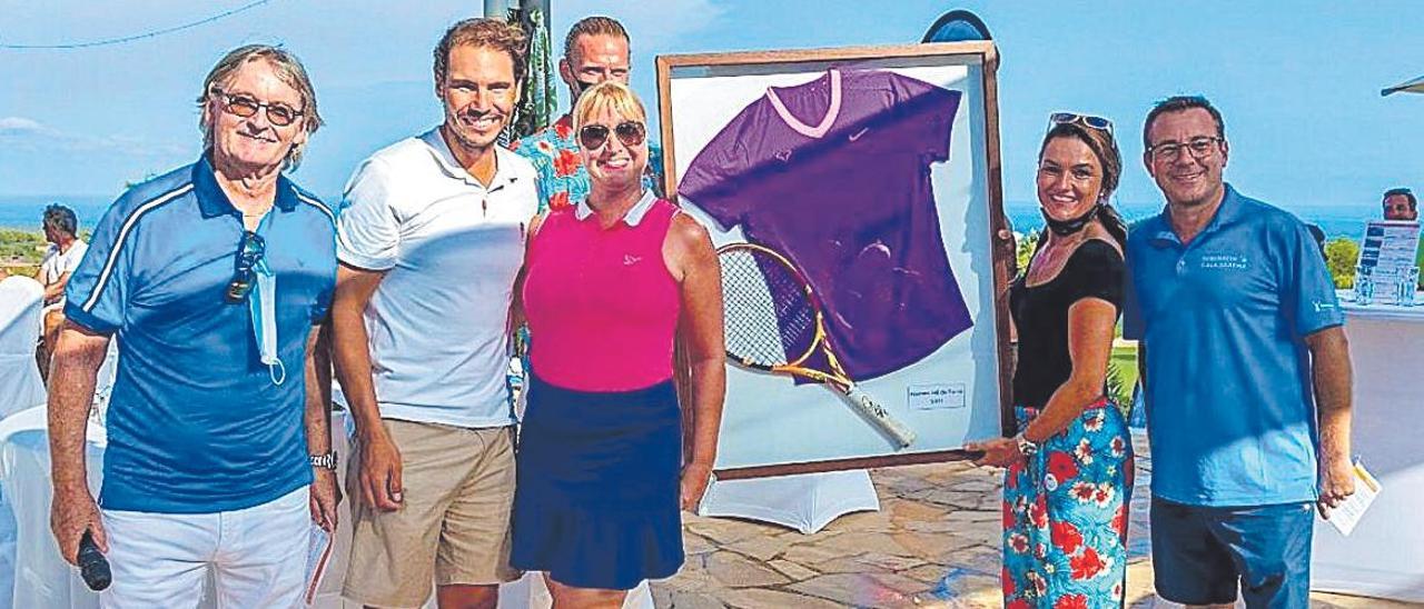 La ciudadana alemana abrazada a Rafael Nadal en presencia de Monti Galmés pagó 5.500 euros por el lote de la camiseta y la raqueta con las que el tenista ganó este año el torneo de Roma. La subasta del torneo de golf Club Robinson recaudó 41.569 euros para la fundación del campeón.