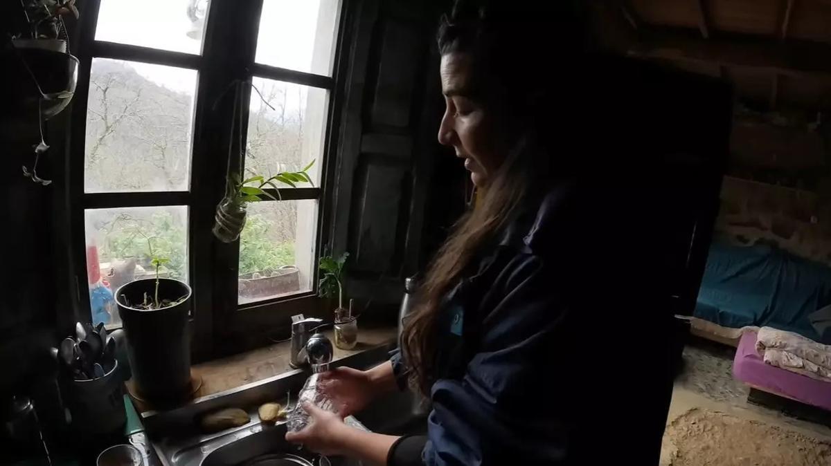 La María rentant un got a mà, ja que no té rentaplats