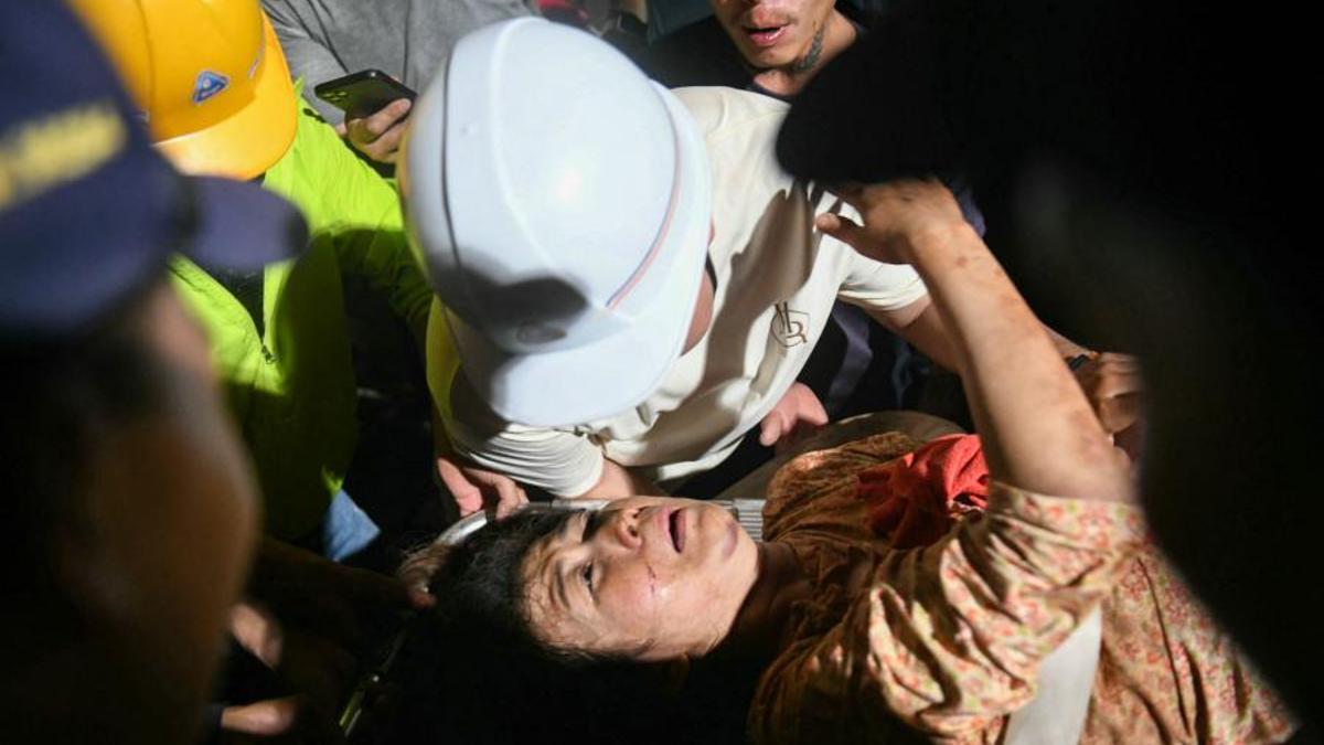 Un hombre evacúa a su esposa al hospital tras el terremoto en Mandalay.