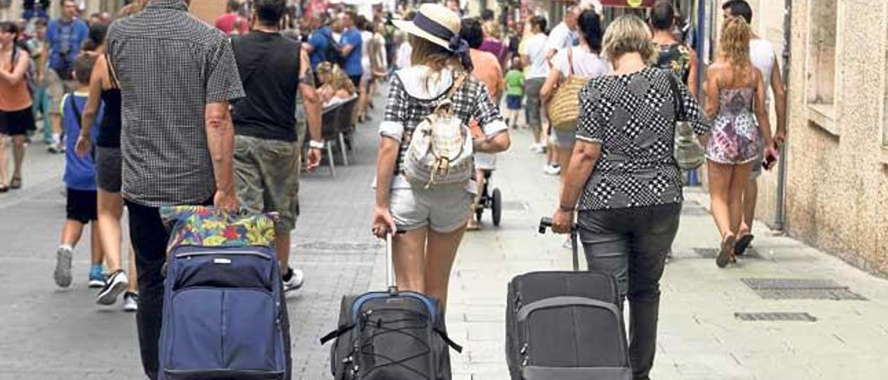 Turistas con maletas por el centro de Palma, una escena cada vez más habitual, con la proliferación de hoteles urbanos y el auge del alquiler turístico ilegal.