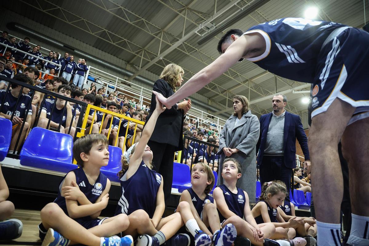 Robert Cosialls choca la mano con uno de los jugadores de la cantera, en el polideportivo de Pumarín