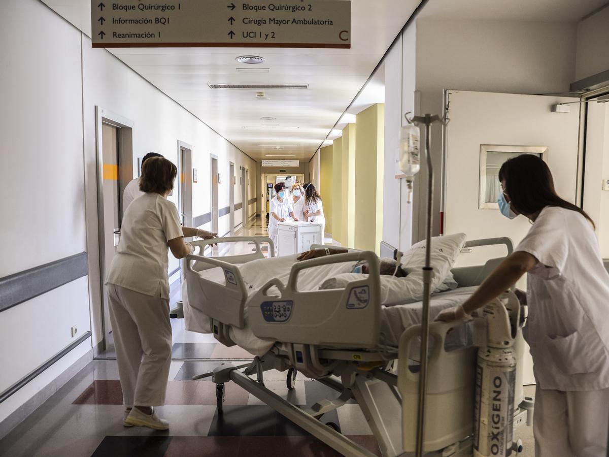 Varios celadores trasladan a un paciente en el HUCA.