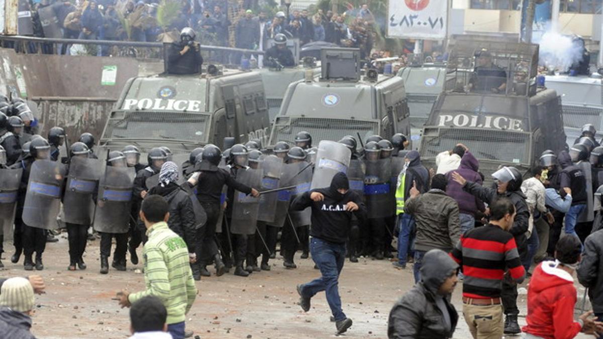 Opositores al presidente egipcio Mohamed Mursi, lanzan piedras contra sus simpatizantes y la policía, en Alejandría, el pasado día 21.