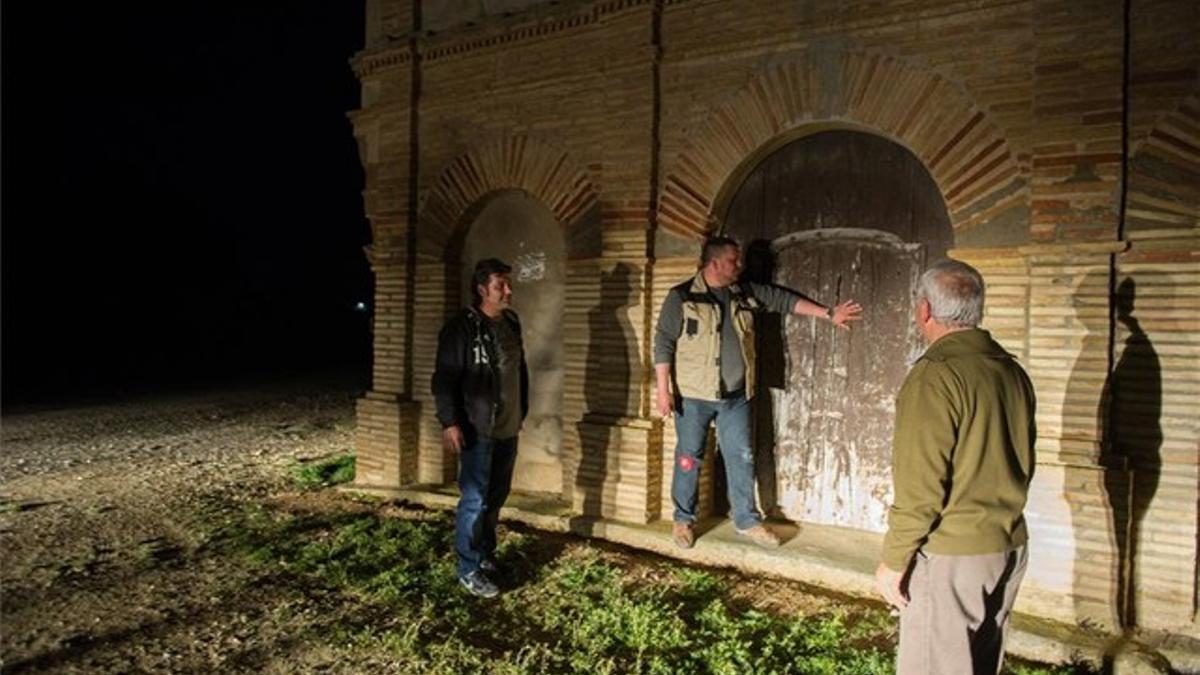 Miembros de un somatén de Lleida, controlan que este cerrada la puerta de un recinto.