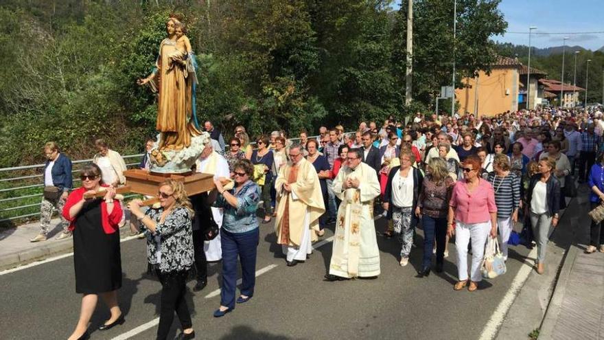 La Virgen de la Salud de Cañu, saliendo en procesión ayer. A la derecha, jóvenes portan el ramu y las imágenes de San Miguel y del Ángel de la Guarda.