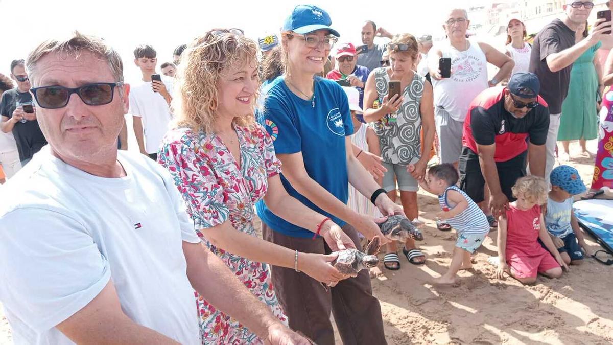 Una imagen de instantes antes de soltar las tortugas al mar en la playa de Piles con la alcaldesa al frente
