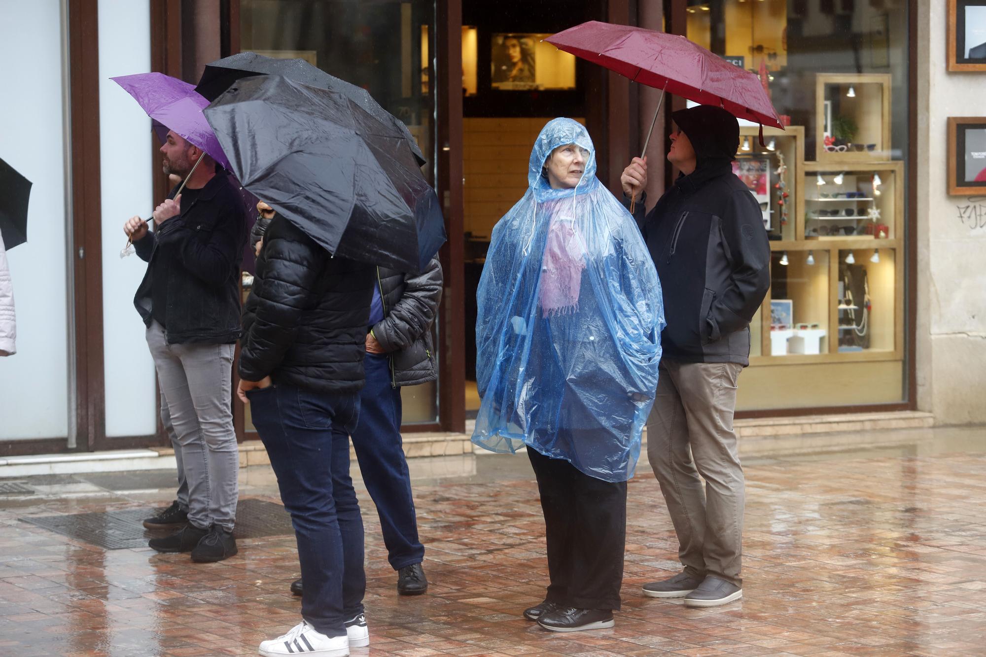 La gente se protege de la fuerte lluvia en Málaga, este 9 de diciembre.