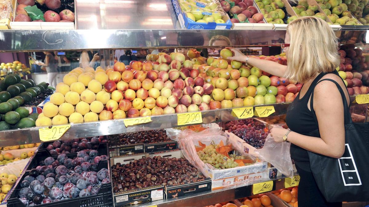 Una mujer compra fruta.