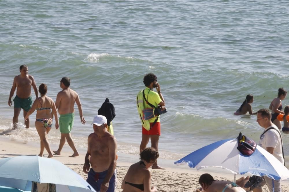 El buen tiempo anima a los bañistas en la playa de Samil