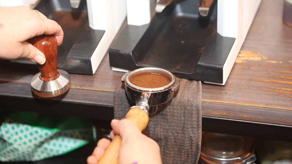 Una camarera prepara un café en un bar