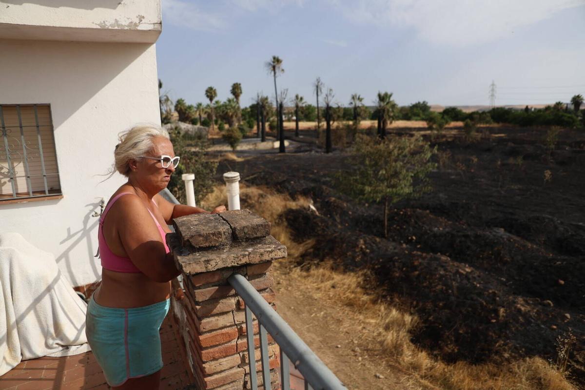 Delia Martínez muestra la zona afectada por el incendio, a escasos metros de su casa.