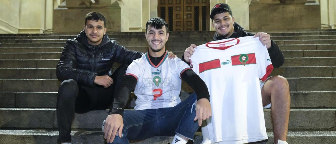 Hatim Nahal, Abdelkader Guettaf i Bilal Ait Mekideche mostren samarretes de la selecció del Marroc a les escales de l’església de Crist Rei | ALEX GUERRERO