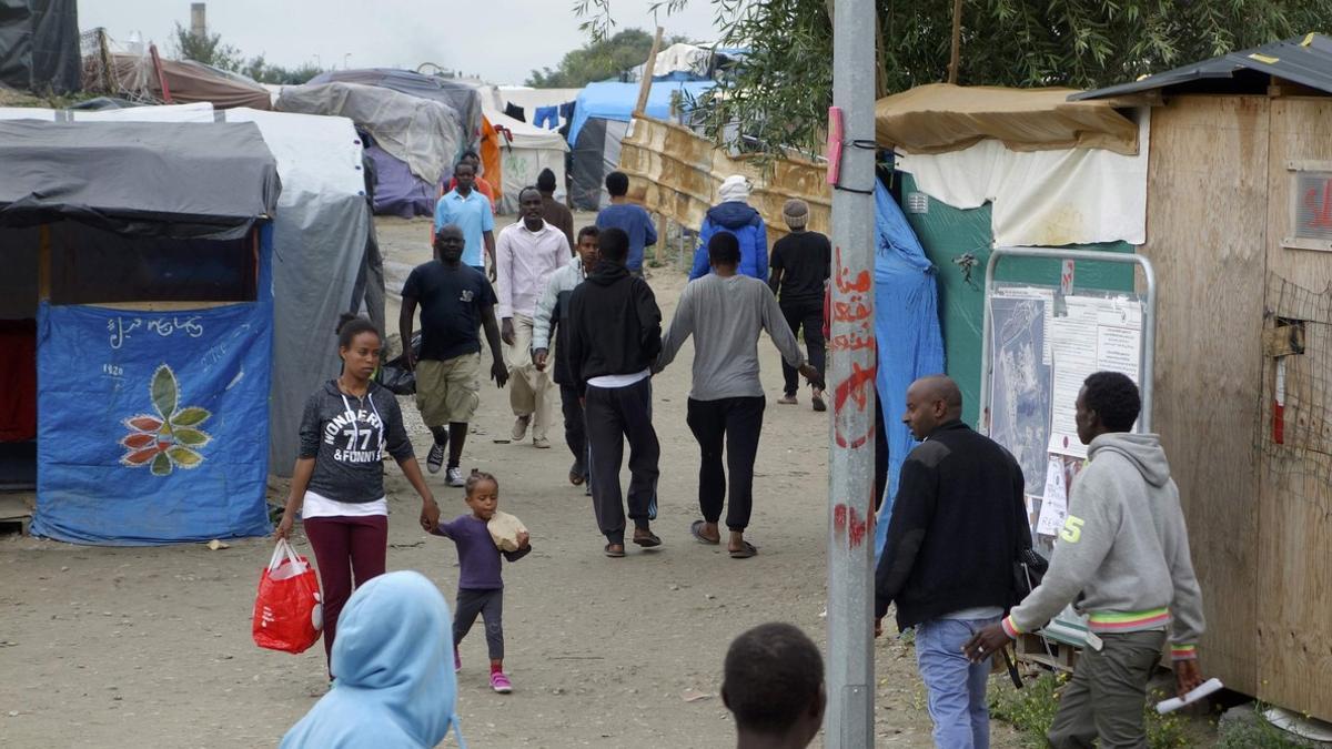 Migrants walk in the northern area of the camp called the 'Jungle&quot; in Calais, France
