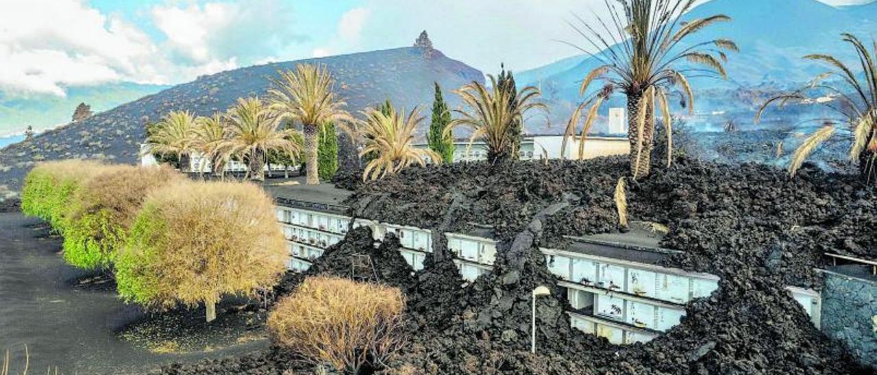 El cementerio de Las Manchas, cubierto parcialmente por la lava que la pasada semana llegó a este punto, con el volcán a lo lejos.
