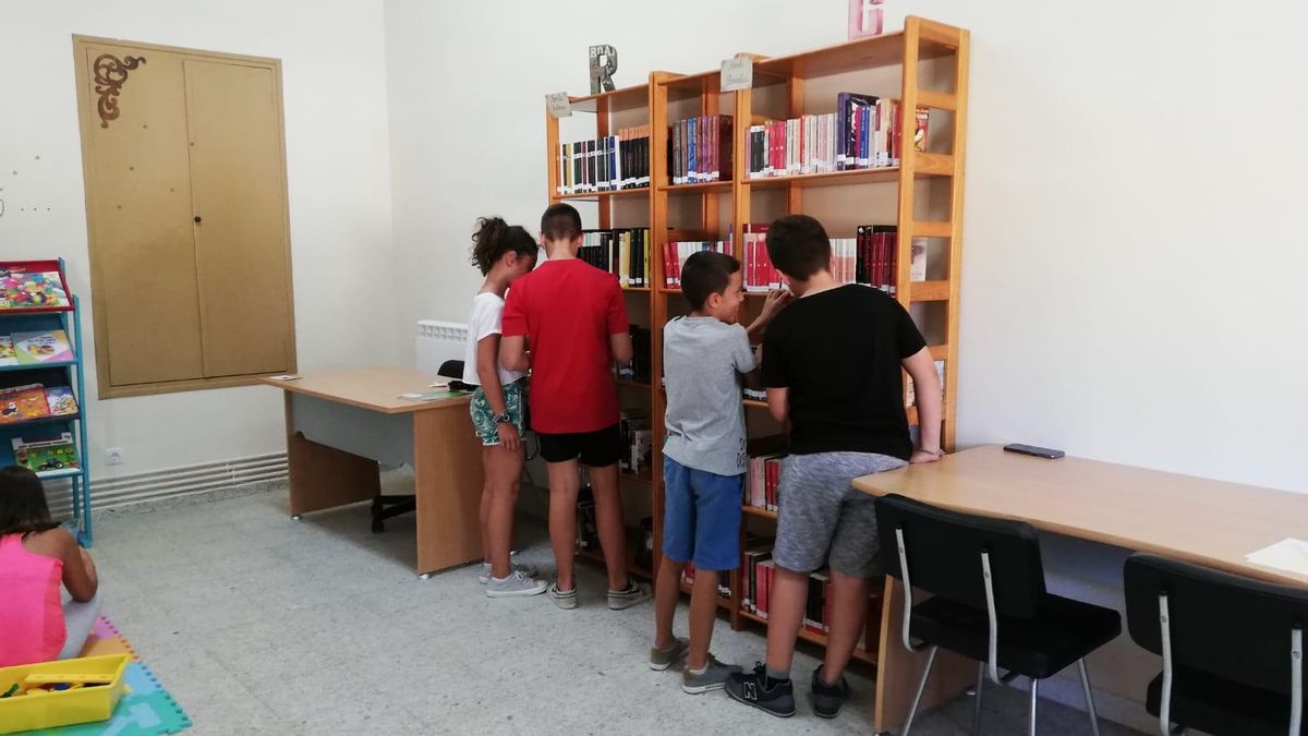 Niños de Peleagonzalo consultan libros de la biblioteca del pueblo