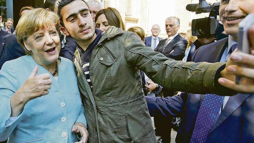 Abas Modamani haciéndose el selfi que cambió su vida con la canciller Angela Merkel en septiembre de 2015.