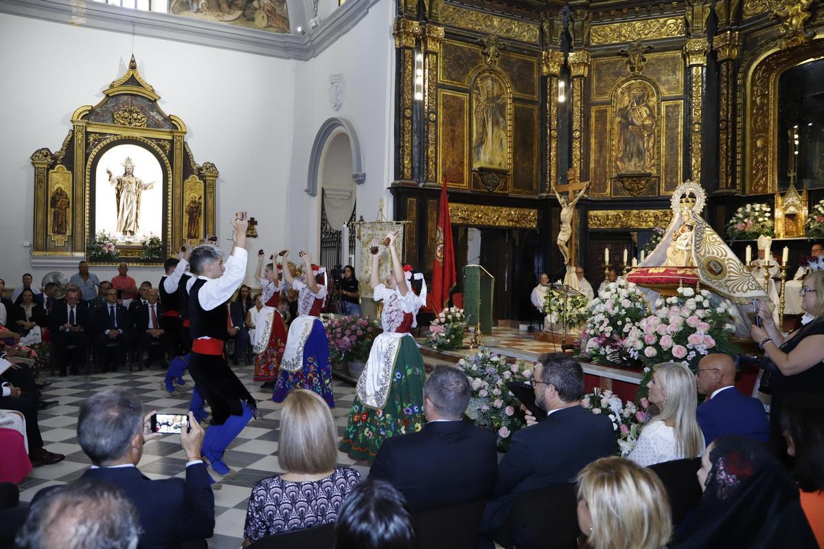 Integrantes de Coros y Danzas bailan ante la Virgen de las Huertas.