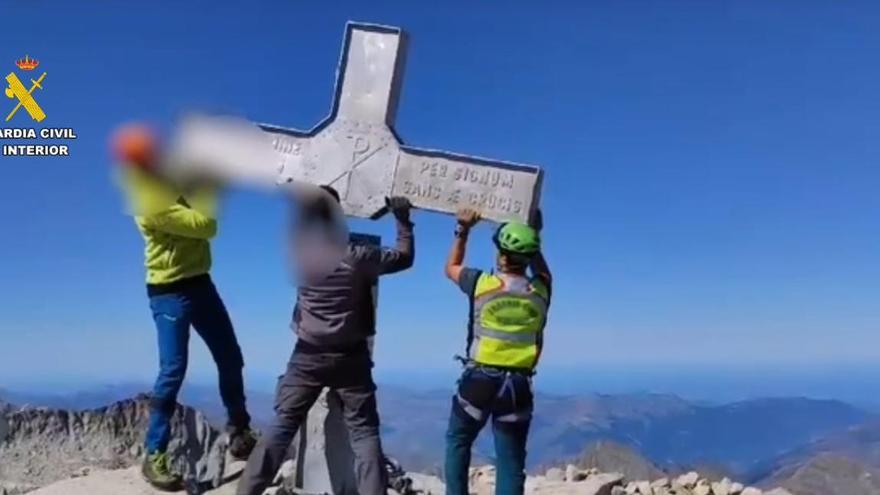 Tres agentes de la Guardia Civil ayudan a desmontar la cruz del Aneto