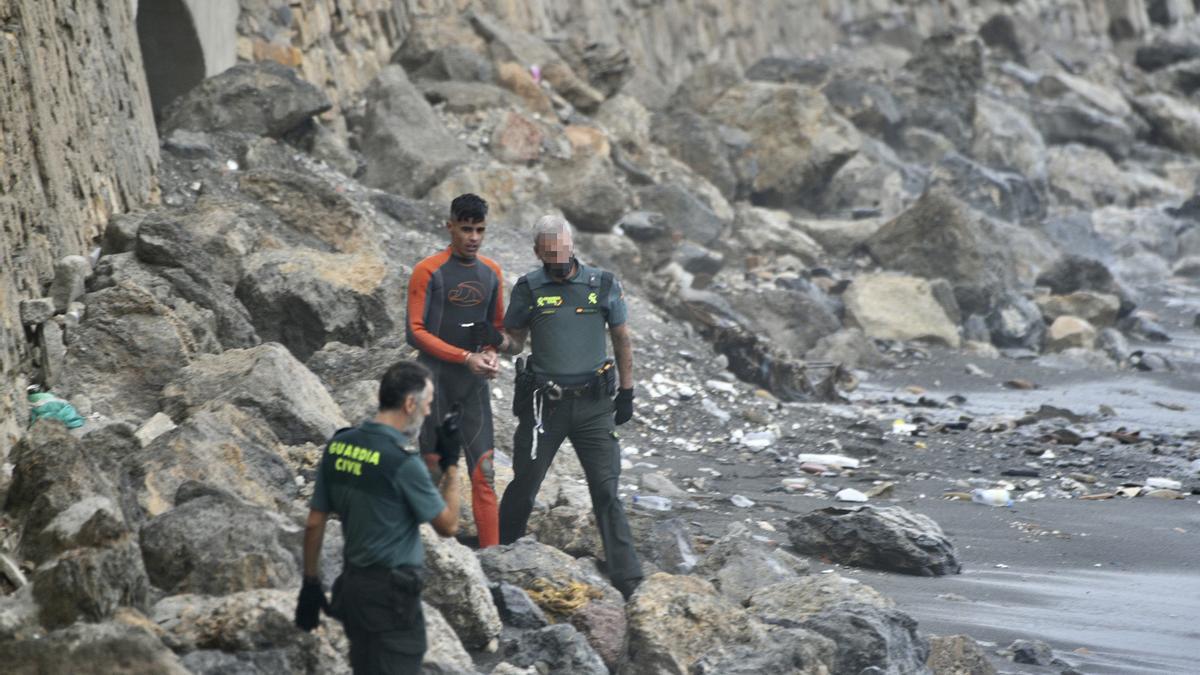 Guardias civiles arrestan a un migrante marroquí que trató de entrar a nado en Ceuta.