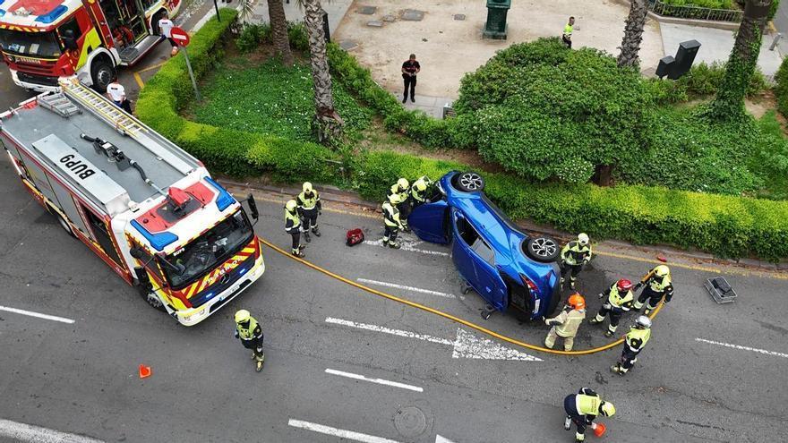 Los bomberos excarcelan a los ocupantes de un vehículo volcado en la Gran Vía Marqués del Turia