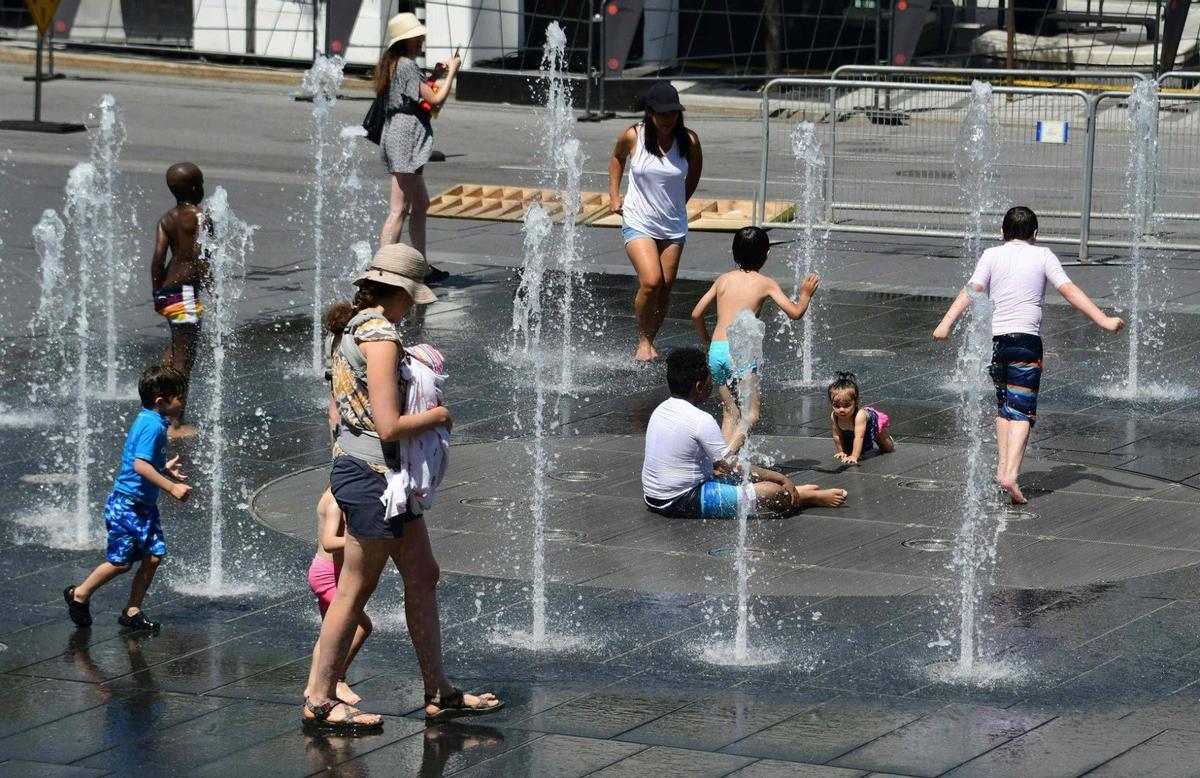 Personas refrescándose en la calle