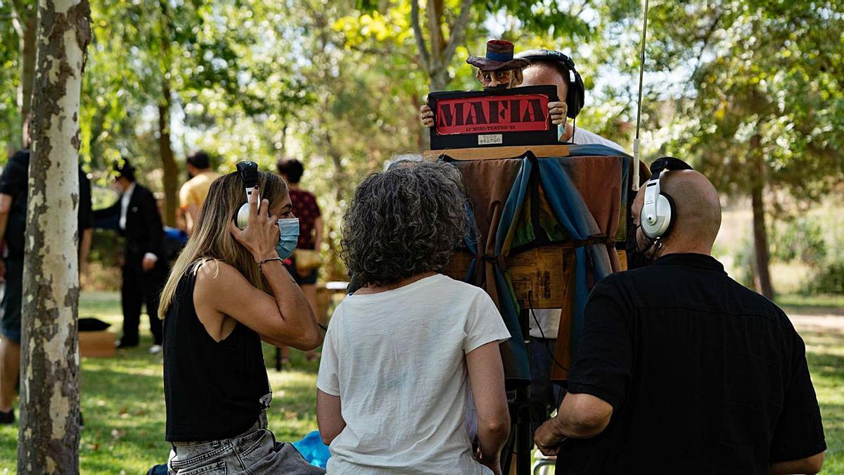 Tres espectadores disfrutan de la muestra de las cajas de teatro en Cabañales.