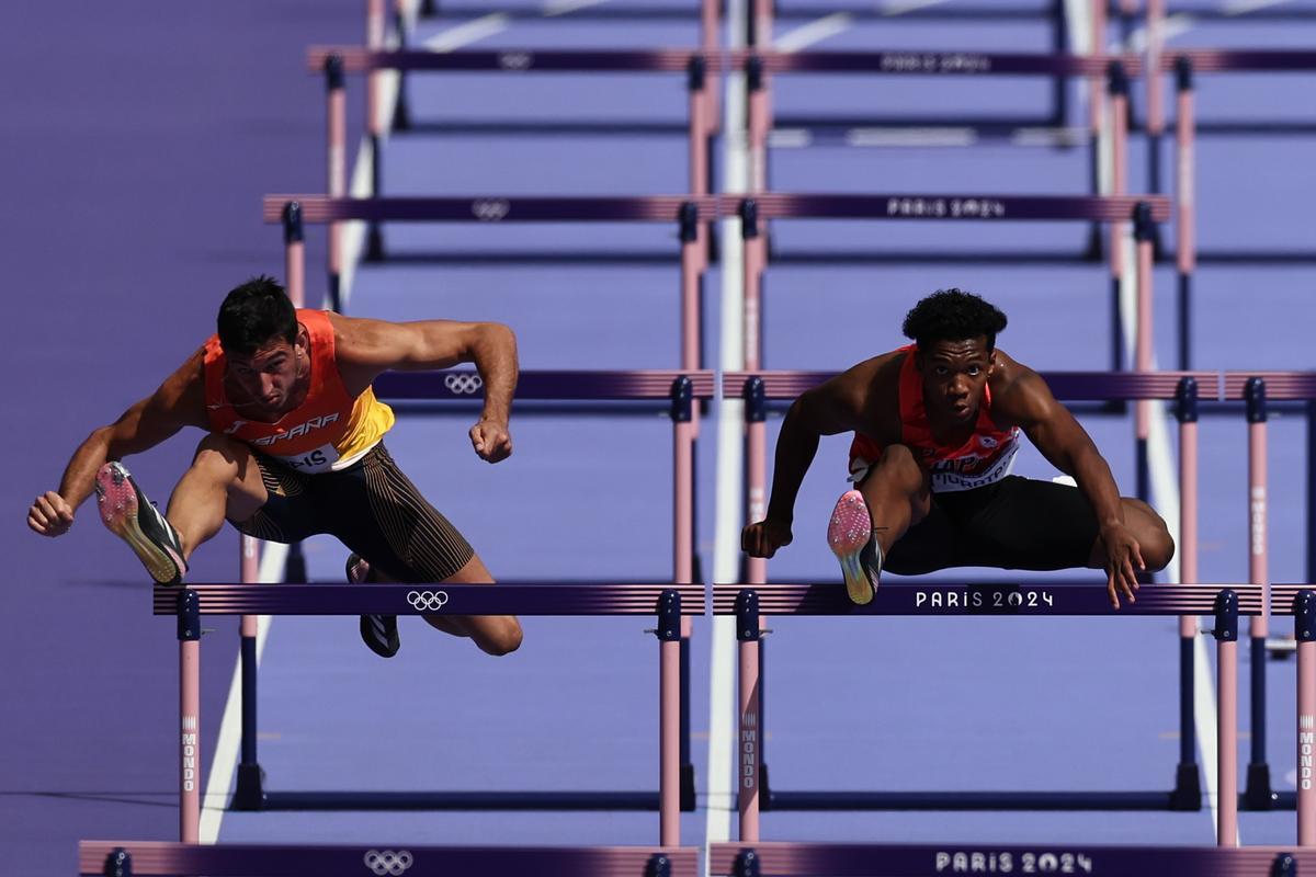 El atleta español Enrique Llopis (i) compite en la primera serie de los 110m valla masculinos en los Juegos Olímpicos de París 2024 en el Estadio de Francia, este domingo, en la capital gala.
