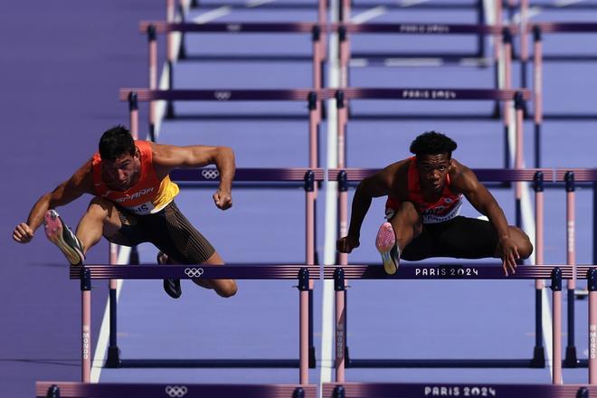 El atleta español Enrique Llopis (i) compite en la primera serie de los 110m valla masculinos en los Juegos Olímpicos de París 2024 en el Estadio de Francia, este domingo, en la capital gala. 