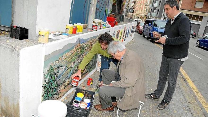 Casacuberta, assegut al costat de Pérez, i Eduard de Pobes, dret al darrere, ahir pintant els murals