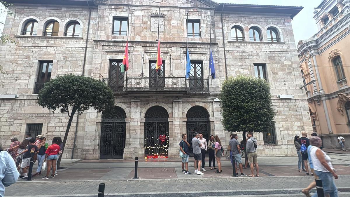 La fachada del Ayuntamiento de Llanes, con flores y velas en homenaje a Laura.
