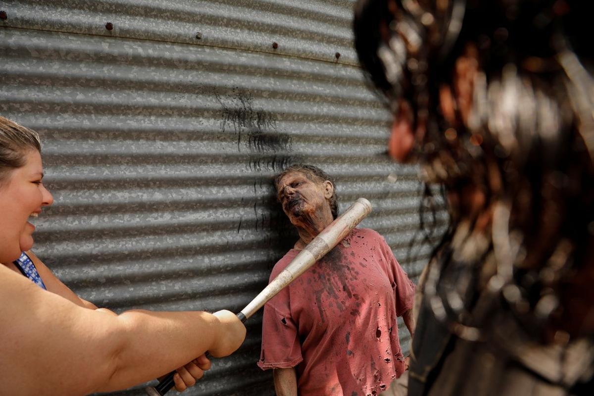 Tourist Amy Powers pretends to kill  Walker Terrie Hamrick during The Walking Dead Tour of a Season 3 location of the AMC production in Haralson, Georgia, U.S. June 15, 2019. Picture taken on June 15, 2019.  REUTERS/Chris Aluka Berry