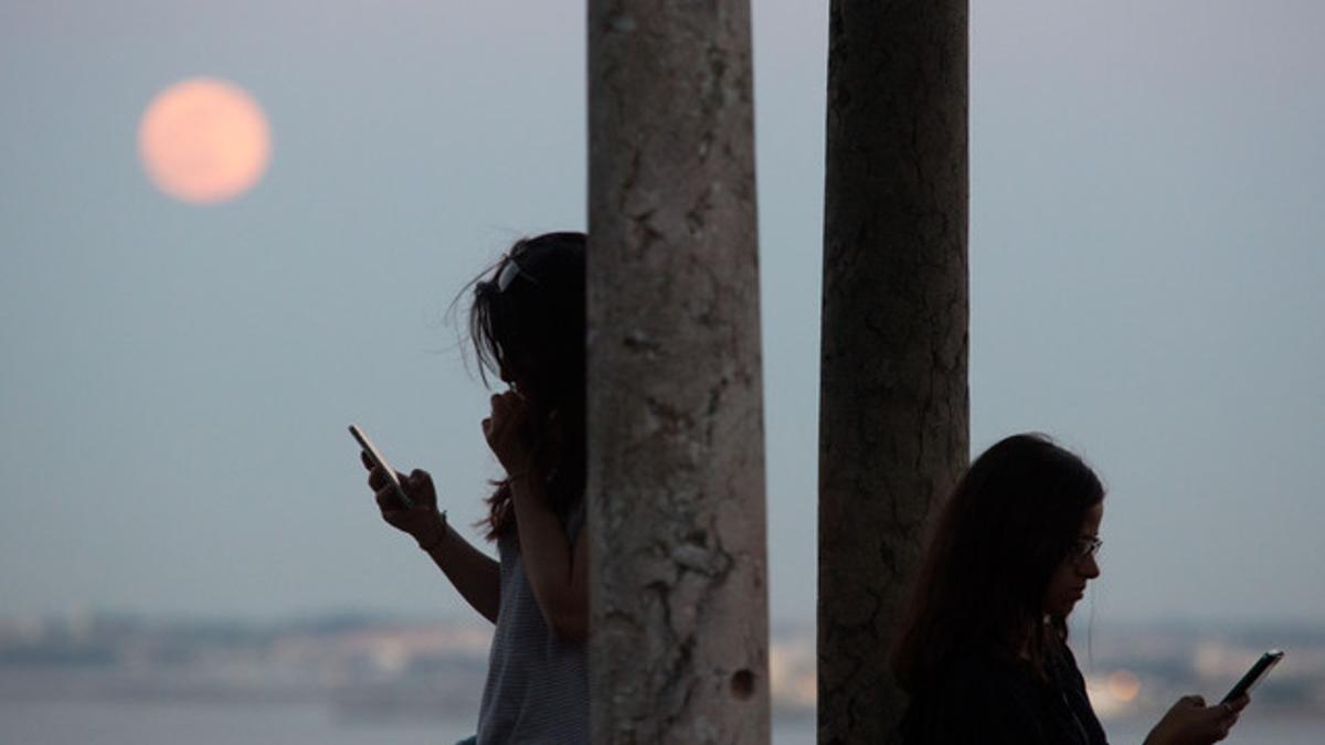 Dos chicas usando su teléfono.