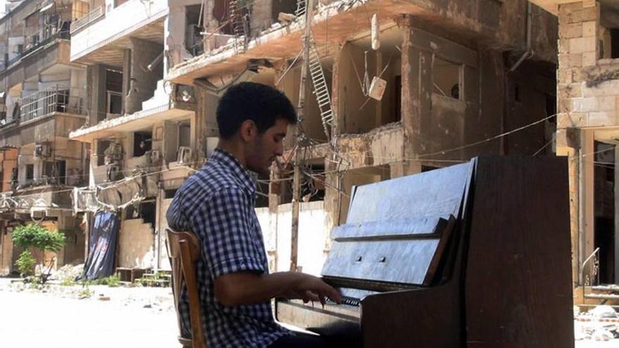 Ahmad toca el piano rodeado por los escombros de los bombardeos en la periferia de Damasco.