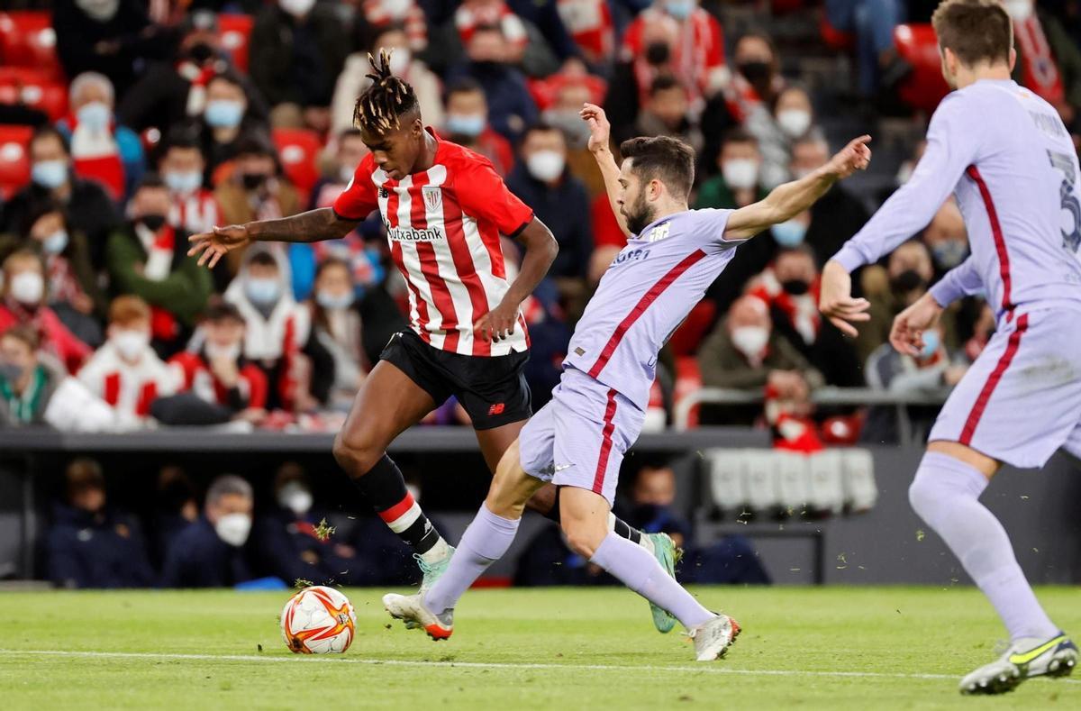 BILBAO, 20/01/2022.- El delantero del Athletic Club, Nico Williams (i), se intenta llevar el balón ante el defensa del FC Barcelona, Jordi Alba, durante el encuentro correspondiente a los octavos de final de la Copa del Rey que disputan hoy jueves en el estadio de San Mamés, en Bilbao. EFE / Luis Tejido.